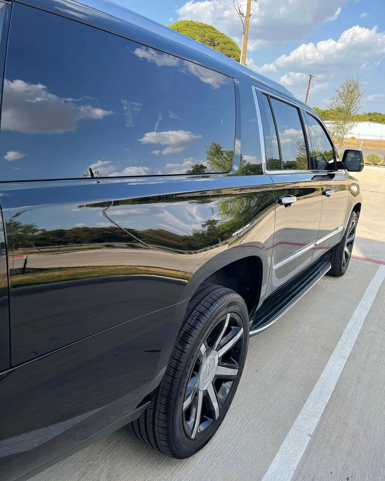 Black SUV reflecting the sky after David's exterior detail