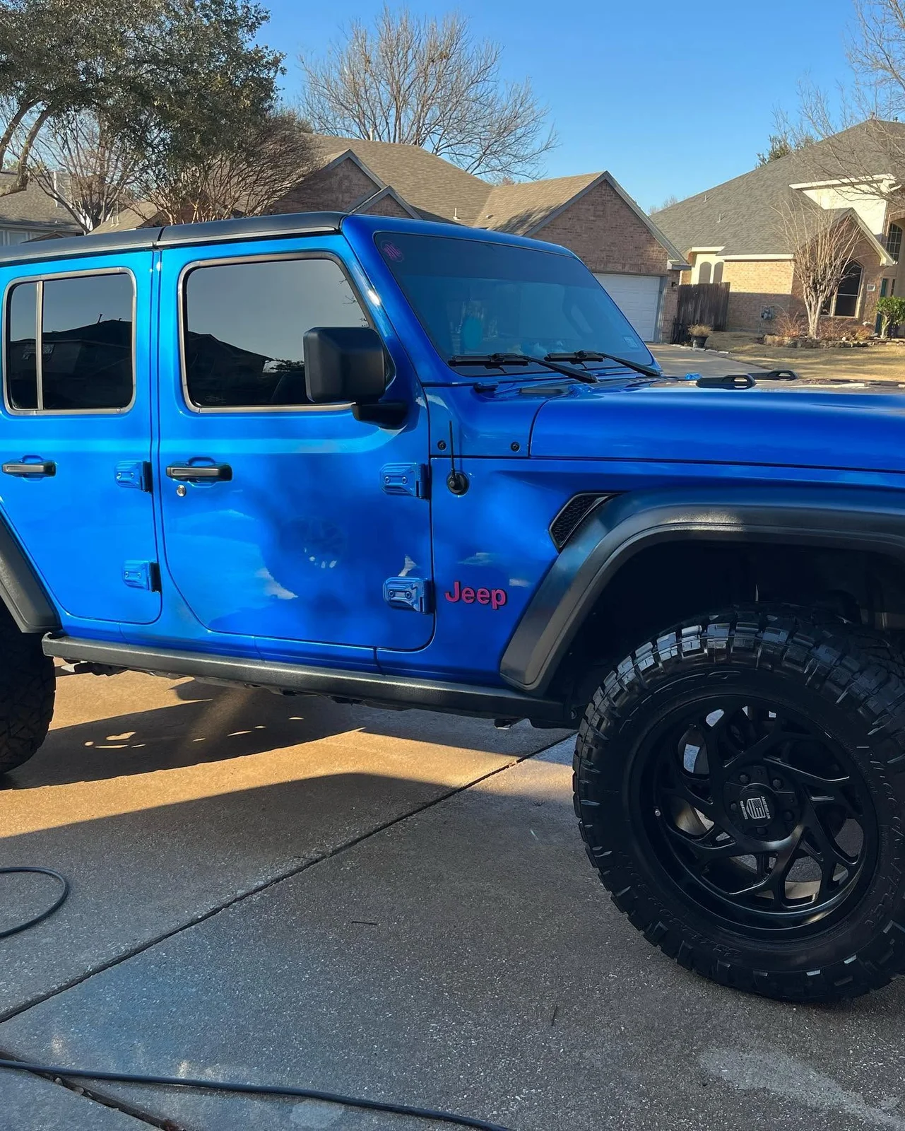 Bright blue lifted Jeep after an exterior detail