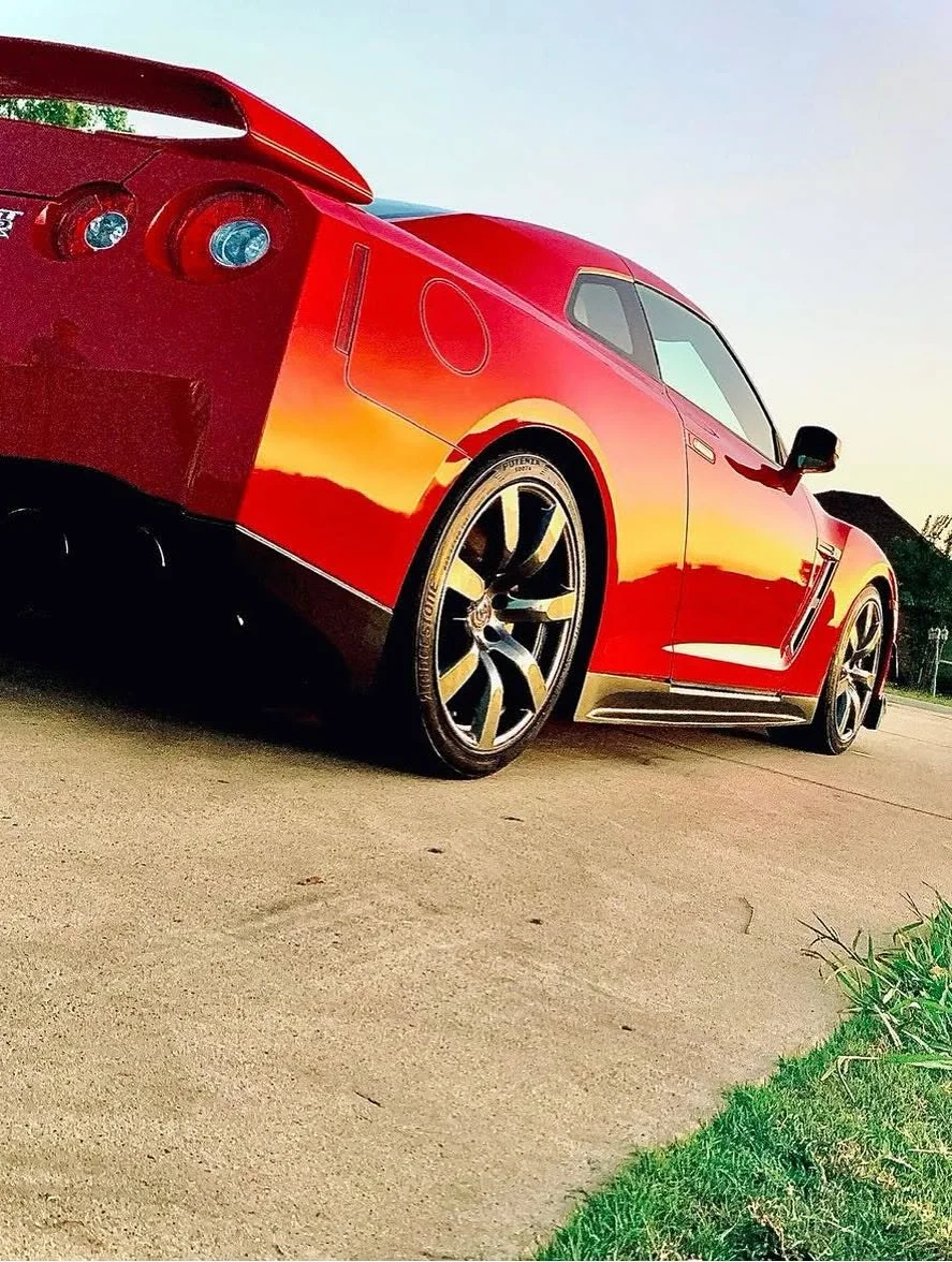 Glossy red Nissan GT-R photographed from the rear three-quarter