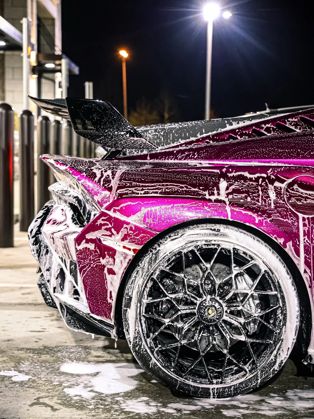 Magenta Lamborghini covered in foam during the wash process