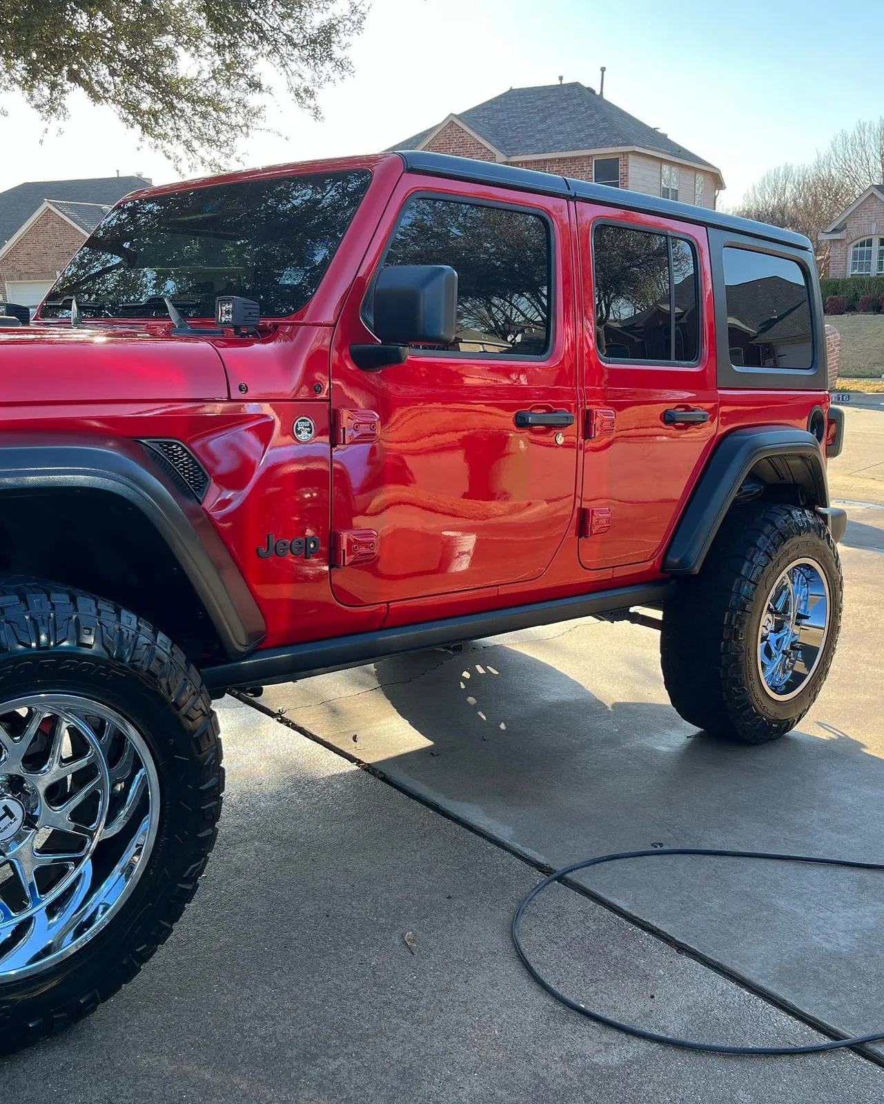 Red lifted Jeep with a glossy exterior finish